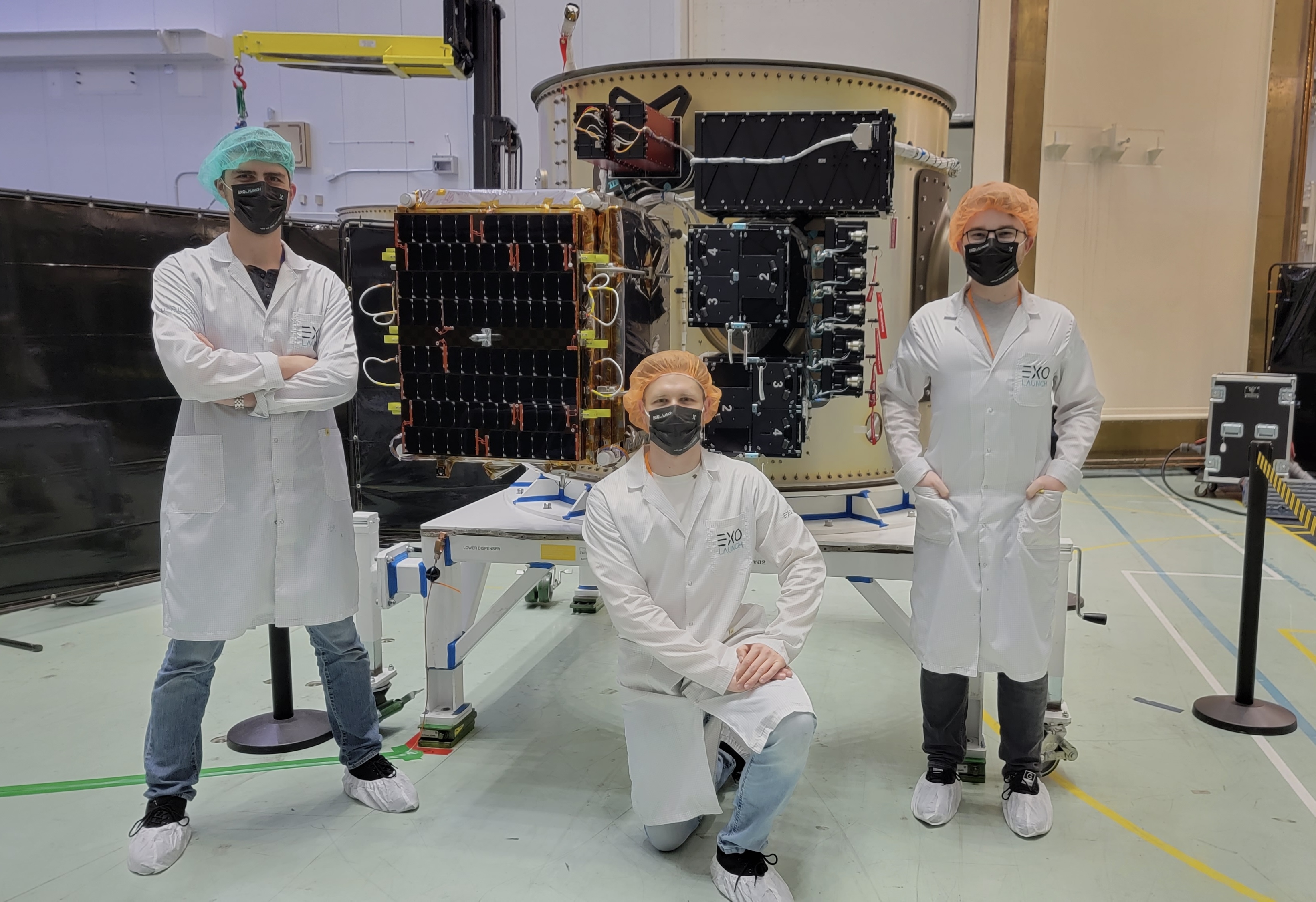 Zespół firmy Exolaunch podczas integracji satelitów przed startem, od frontu widoczny jest mikrosatelita firmy ICEYE (Źródło: Exolaunch/SpaceX)